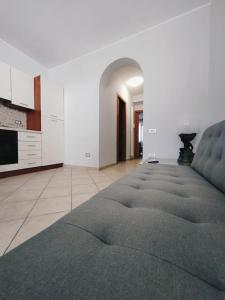 a living room with a large couch and a kitchen at Appartamento Casa Bruno in Porto SantʼElpidio