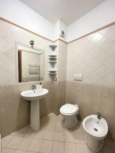 a bathroom with a sink and a toilet and a mirror at Appartamento Casa Bruno in Porto SantʼElpidio