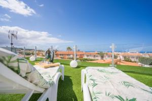 un patio con 2 sillas blancas en el césped en 5 bedrooms villa La Laja, en Callao Salvaje