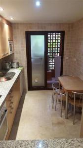 uma cozinha com uma mesa e cadeiras e uma porta em Jardines de Nueva Galera em Estepona
