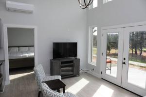 a living room with a television and a bedroom at Golf Views Mount Airy in Mount Airy