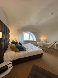 una camera da letto con letto, cuscini e finestra di Palazzo Ferraioli - Hotel & Wellness ad Atrani
