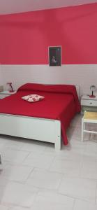 ein rotes Schlafzimmer mit einem Bett mit einer roten Wand in der Unterkunft Casa Vacanze Villa Giacetta in Santa Maria Del Focallo