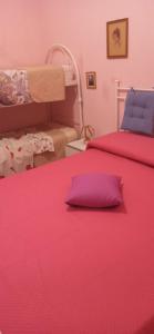1 Schlafzimmer mit 2 Betten mit rosa Bettwäsche und einem Kissen in der Unterkunft Casa Vacanze Villa Giacetta in Santa Maria Del Focallo