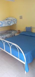 Schlafzimmer mit einem Bett mit blauer Decke in der Unterkunft Casa Vacanze Villa Giacetta in Santa Maria Del Focallo