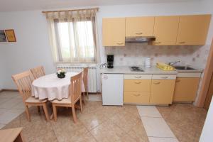 una pequeña cocina con mesa, mesa y sillas en Guest House Liliana, en Rovinj