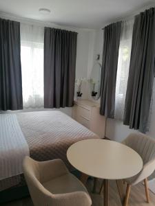 ポドストラナにあるApartments and Rooms Tomasのベッドルーム1室(ベッド1台、白いテーブルと椅子付)