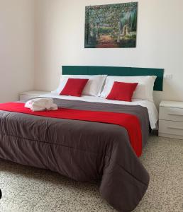 una camera da letto con un grande letto con cuscini rossi di Hotel Migani a Rimini