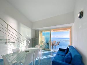 een woonkamer met een blauwe bank en een glazen tafel bij Grand Bleu Magarà in Cefalù