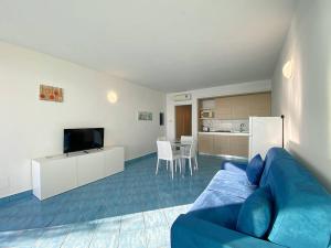 een woonkamer met een blauwe bank en een keuken bij Grand Bleu Magarà in Cefalù +13 foto's