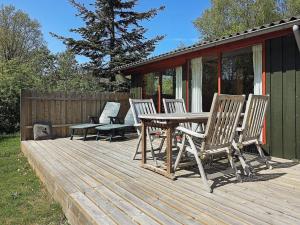 a wooden deck with a table and chairs on it at 6 person holiday home in L s in Læsø