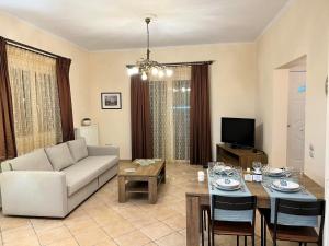 a living room with a couch and a table at Villa Maria - Koropi in Koropi