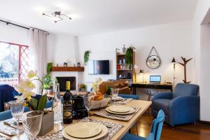 a living room with a table and blue chairs at 3 Quartos no Capivari com Lareira in Campos do Jordão