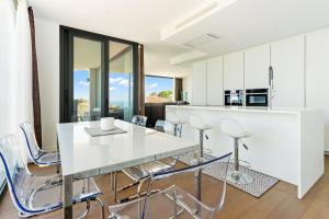 una cucina e una sala da pranzo con tavolo e sedie bianchi di Villa de Lujo Welcs PDA 073 con Piscina y Vistas al Mar a Platja  d'Aro