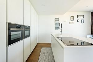 una cocina con armarios blancos y fregadero en Villa de Lujo Welcs PDA 073 con Piscina y Vistas al Mar, en Platja d'Aro