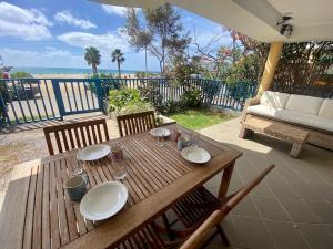 een houten tafel met borden en wijnglazen op een patio bij Leme Bedje Sea View Apartments with Pool in Santa Maria