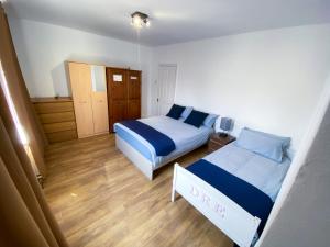 - une petite chambre avec 2 lits et du parquet dans l'établissement 4 BEDROOM HOUSE PARKING & GARDEN NEAR CENTRAL LONDOn, à Londres