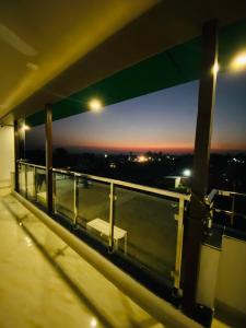 a balcony with a view of the city at night at GREEN DANDI HOMESTAY in Rishīkesh