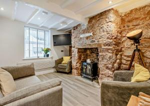 a living room with a stone wall and a fireplace at Bilbos Cottage in Shaldon
