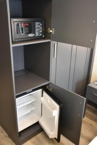a small kitchen with a refrigerator and a microwave at Shishly Palace Hotel in Istanbul