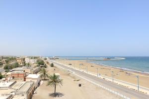 索哈尔مارينا للغرف الفندقية的享有棕榈树海滩和大海的景色