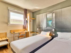 a hotel room with two beds and a window at B&B HOTEL Clermont-Ferrand Sud Aubière in Aubière