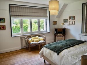 a bedroom with a bed and a chair and a window at Manoir au coeur du triangle d or au Touquet in Le Touquet-Paris-Plage