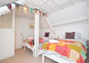 a bedroom with two beds and a canopy bed at Bluebell Cottage - Seaton in Seaton