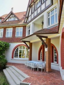 una casa con un tavolo e sedie su un patio in mattoni di Manoir au coeur du triangle d or au Touquet a Le Touquet-Paris-Plage