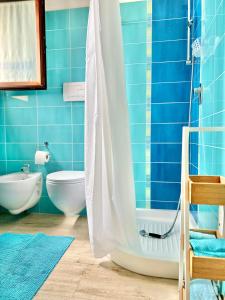 ein blaues Bad mit einer Dusche und einem WC in der Unterkunft Apartments MADEJ 3 in Bari Sardo