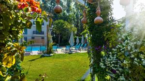 Uras Beach Hotel في فتحية: حديقة بها مجموعة من الزهور والكراسي