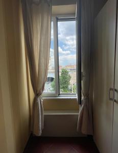 una ventana con cortinas y vistas a la ciudad en Santa Bibiana en Roma