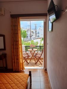 a room with a door open to a patio with a table at P&G APARTMENTS in Naxos Chora