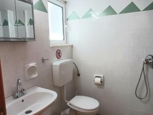 a bathroom with a toilet and a sink and a mirror at P&G APARTMENTS in Naxos Chora