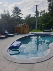 una piscina con una silla y un banco. en Maison Le Lézard chez Amalia et Fred en Thonon-les-Bains