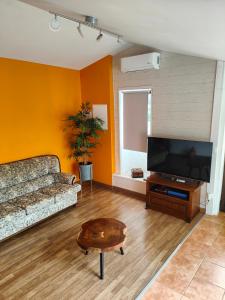 Casinha da Ladeira 3360 في بيناكوفا: غرفة معيشة مع أريكة وطاولة قهوة