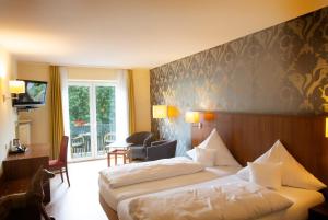 a hotel room with two beds and a balcony at Bad Emser Hof in Bad Ems