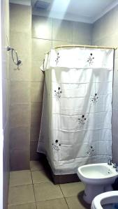 uma casa de banho com uma cortina de chuveiro e um WC. em Complejo Residencial Privado 2 em El Challao