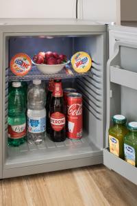einen offenen Kühlschrank mit Getränken und einer Schale Obst in der Unterkunft Hispirya Rooms in Terracina