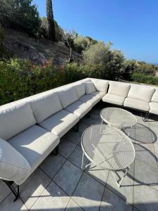 ein weißes Sofa und einen Tisch auf der Terrasse in der Unterkunft Calm & Joy - Poseidonia in Posidhonía