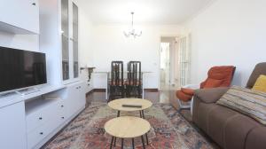 a living room with a couch and a tv at Ático Laxe Grande in A Guarda