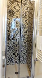 a shower in a bathroom with black and white tiles at CASATA in Copertino +39 photos