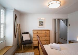 um quarto com uma cama, uma cómoda e uma cadeira em Ravenswell em Dartmouth