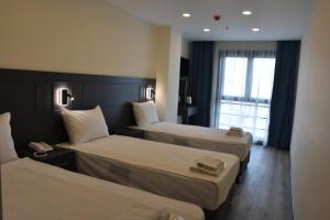 een hotelkamer met 2 bedden en een raam bij Shishly Palace Hotel in Istanbul