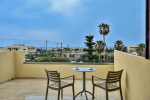 a table and chairs on a balcony with a view of the ocean at Despo Hotel in Gouves