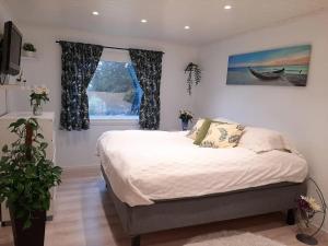 Un dormitorio con una cama grande y una ventana en Cosy family home with pool en Grimstad