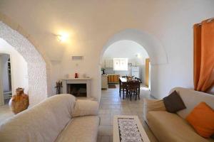 a living room with a couch and a dining room at Trullo Antico with exclusive swimming pool in Cisternino