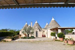 a large house with turrets on the side of it at Trullo Antico with exclusive swimming pool in Cisternino