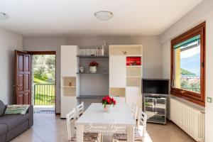 a kitchen and living room with a table and a couch at Casa Aria in Riva di Solto