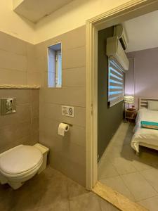 a bathroom with a toilet and a bed at Dar al Majus in Bethlehem